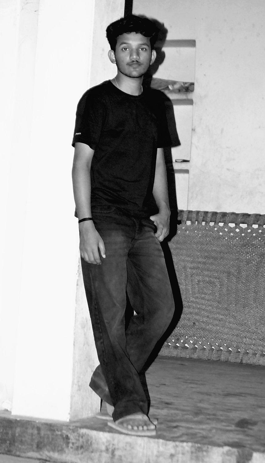 Stillness — full-length monochrome portrait against a wall